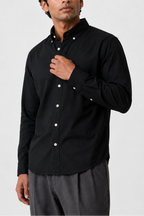 Model wearing Cauzeway black Oxford cotton shirt with button-down collar, posing front view.