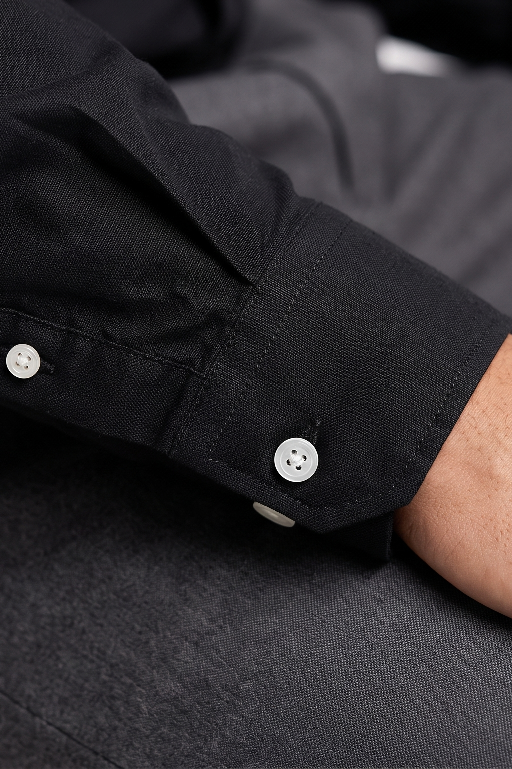 Close up of the button-down collar and Oxford weave texture on Cauzeway solid black shirt.