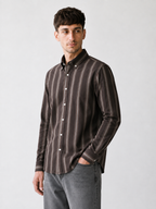 Model wearing Cauzeway brown shadow stripe Oxford cotton shirt, three-quarter view.