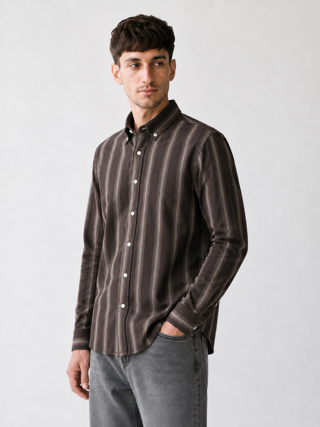 Model wearing Cauzeway brown shadow stripe Oxford cotton shirt, three-quarter view.