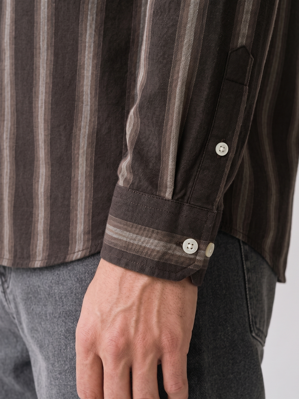Close up of the tailored cuff and shadow stripe pattern on Cauzeway brown Oxford cotton shirt sleeve.