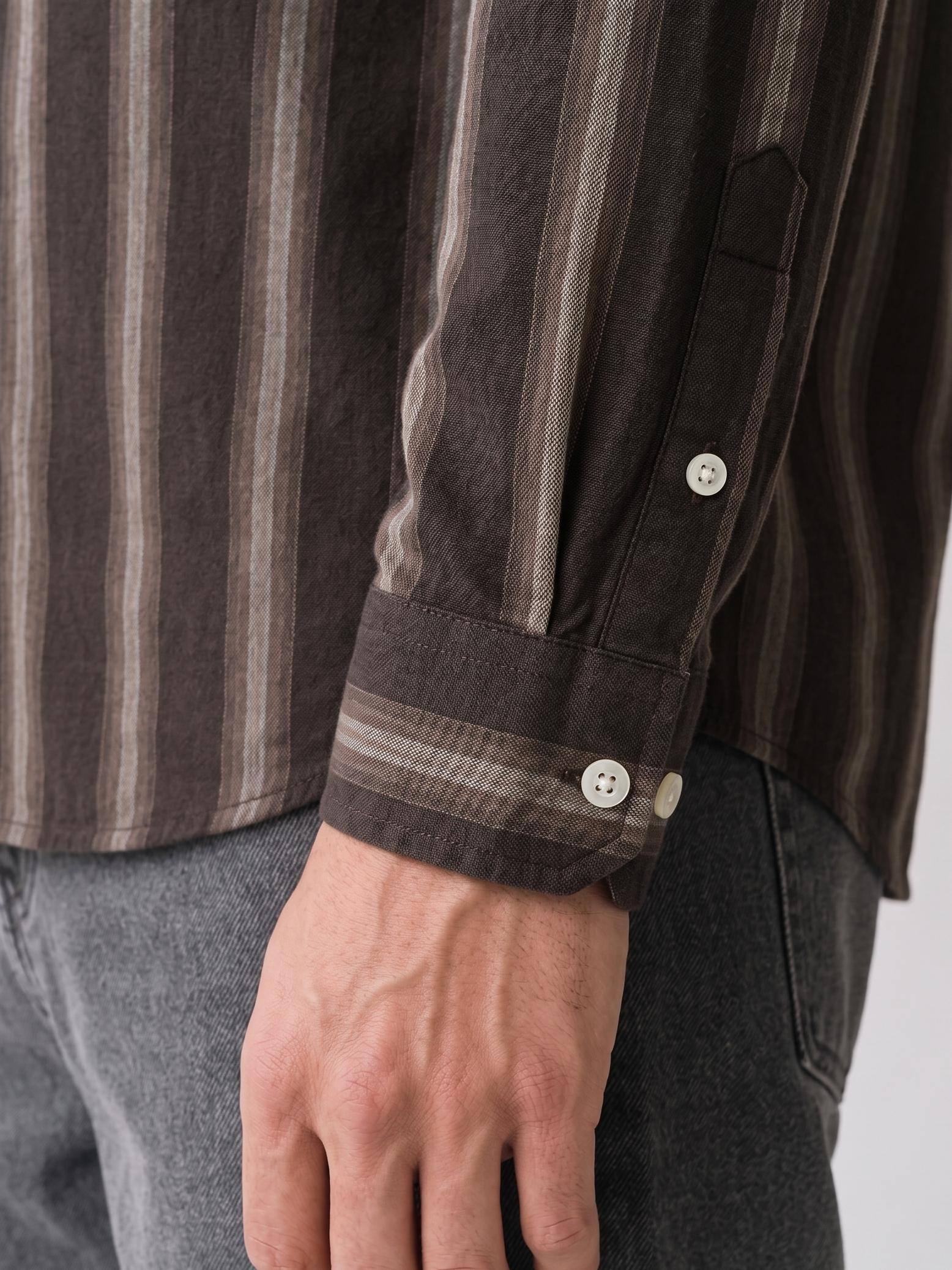 Close up of the tailored cuff and shadow stripe pattern on Cauzeway brown Oxford cotton shirt sleeve.