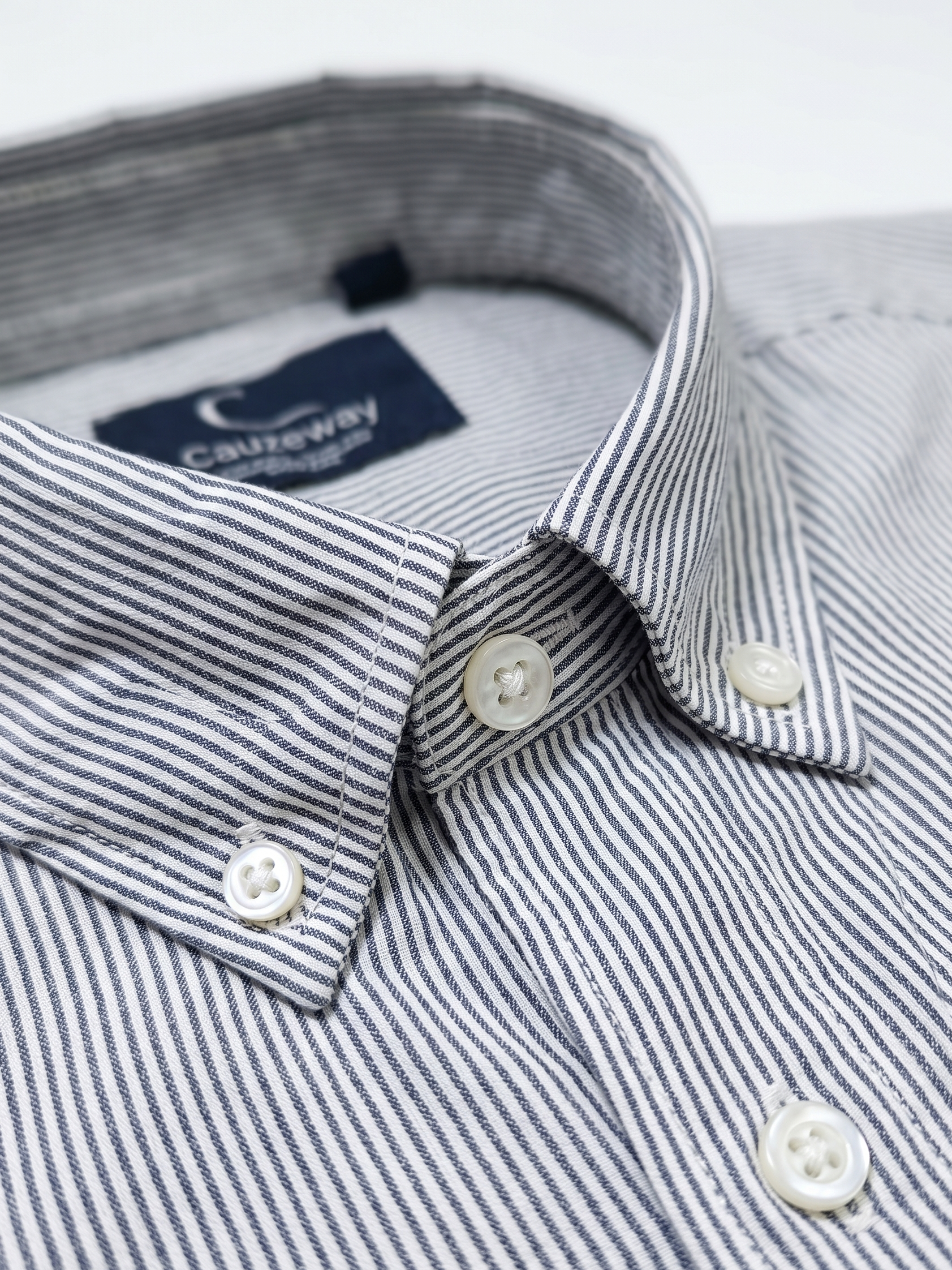 Close up of the button-down collar and pencil stripe weave on Cauzeway charcoal grey shirt.