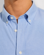 Close up of the button-down collar and Oxford weave on Cauzeway chambray blue shirt.