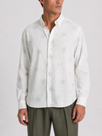 Model wearing Cauzeway white floral print shirt with button-down collar, front view.