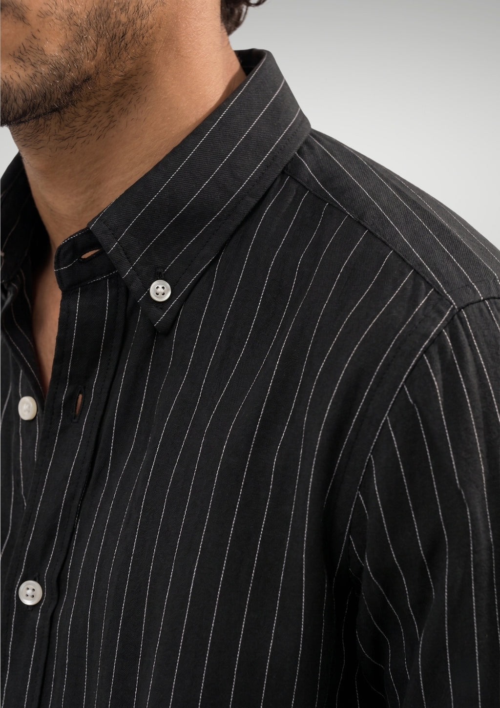 Close up of the black pinstripe pattern on premium 100% cotton TFO oxford fabric and structured button down collar by Cauzeway.