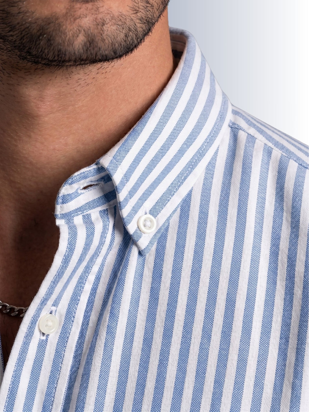 Close up texture of the iconic white and blue university stripe pattern on premium 100% cotton TFO oxford fabric by Cauzeway.