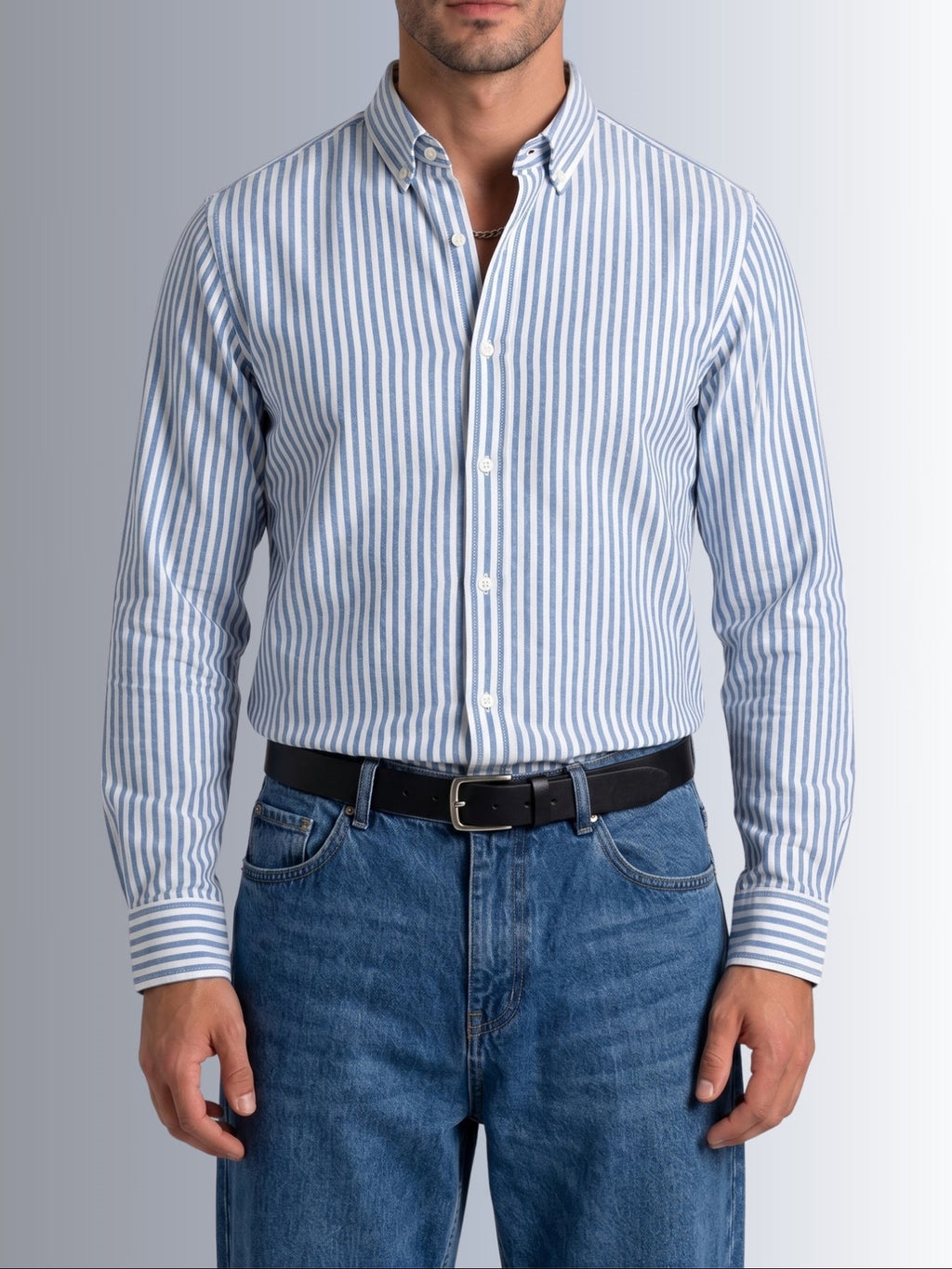 Model showcasing the tucked casual style of Cauzeway blue university stripe shirt engineered for the Indian body type, paired with denim jeans.