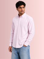 Model showcasing the lightweight untucked drape of Cauzeway pink candy stripe seersucker casual shirt engineered for Indian men, styled with blue washed denim jeans.