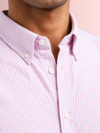 Close up texture of the breathable puckered 100% cotton seersucker weave and structured button down collar on a Cauzeway pink striped shirt.